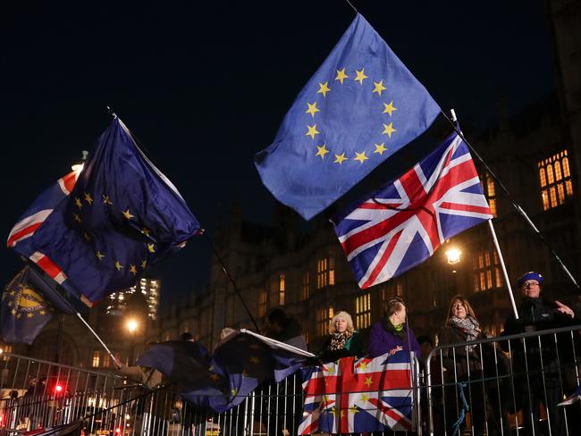 Anti-brexit campaigners wave Union and EU flags outside the Houses of Parliament in central London on December 12, 2018. - British Prime Minister Theresa May vowed to fight "with everything I've got" an attempt on Wednesday by her own Conservative party to remove her from office over her unpopular Brexit deal (Photo by Daniel LEAL-OLIVAS / AFP)