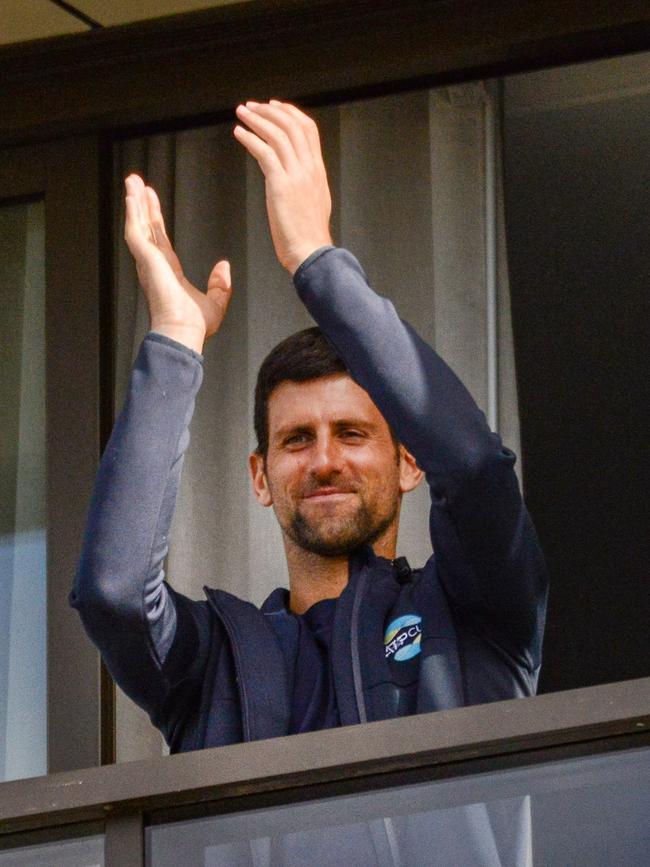 Novak Djokovic of Serbia gestures from his hotel balcony on the last day of his two-week quarantine in Adelaide in January, 2021. Picture: Brenton Edwards/AFP