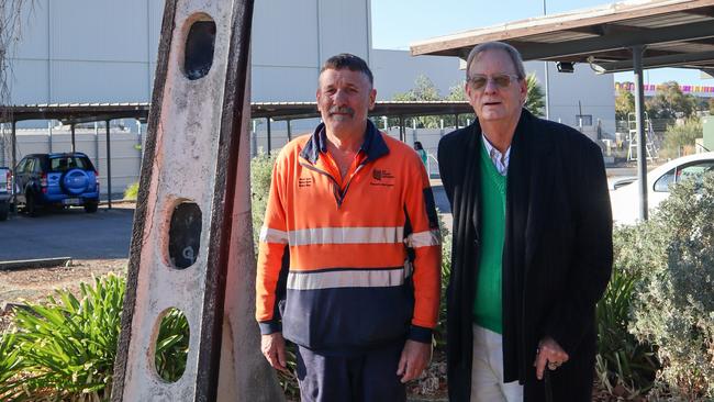 Brian Docking, Stobie pole manufacturing co-ordinator at SA Power Networks, Angle Park. He’s standing next to the original Stobie pole from 1924 with Peter Goers. Picture: Supplied.