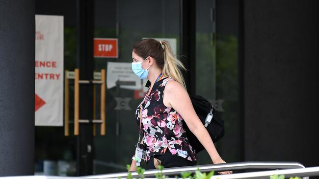 A woman wearing a face mask enters the Hotel Grand Chancellor in Spring Hill, Brisbane, where a worker of the hotel and a quarantining child who recently returned from overseas tested positive to coronavirus. Picture: NCA NewsWire / Dan Peled