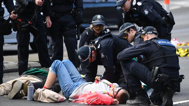 Police work to remove an activist superglued to a Melbourne bridge. Picture: AAP Image/Erik Anderson