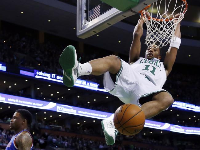 Boston Celtics guard Evan Turner (11) hangs from the rim after dunking against the Sacramento Kings.