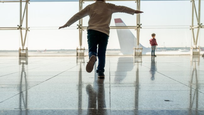 Mother playing with her children at the airport