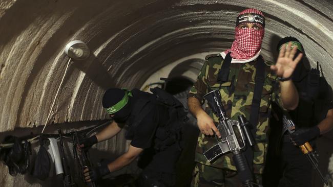 A Palestinian fighter from the Izz el-Deen al-Qassam Brigades, the armed wing of the Hamas movement, gestures inside an underground tunnel in 2014 to dispute Israel's claim that it had demolished all of the Islamist group's border infiltration tunnels. Picture: Reuters/Mohammed Salem