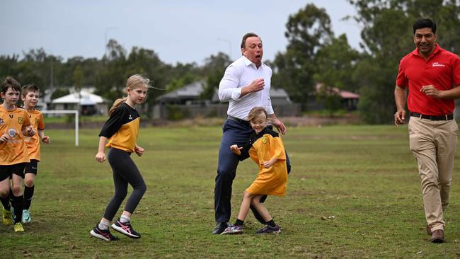 Premier Steven Miles nearly knocks over a small soccer player from the Dinmore Bushrats football club in Riverview. Picture: Lyndon Mechielsen