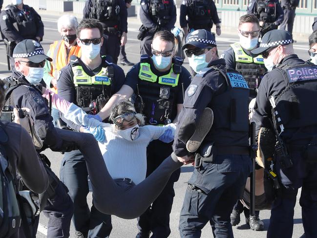 Climate activists block the Princes Bridge in Melbourne.  Wednesday, Police remove protesters who glued their hands to the road.. October 27, 2021. Picture: David Crosling