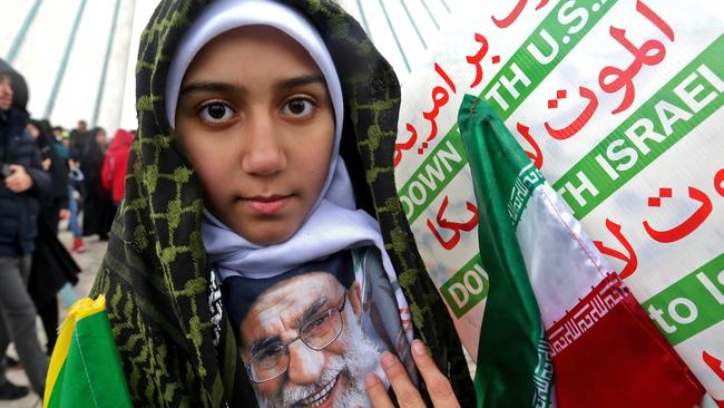 An Iranian girl poses with a portrait of the country's Supreme Leader Ali Khamenei.