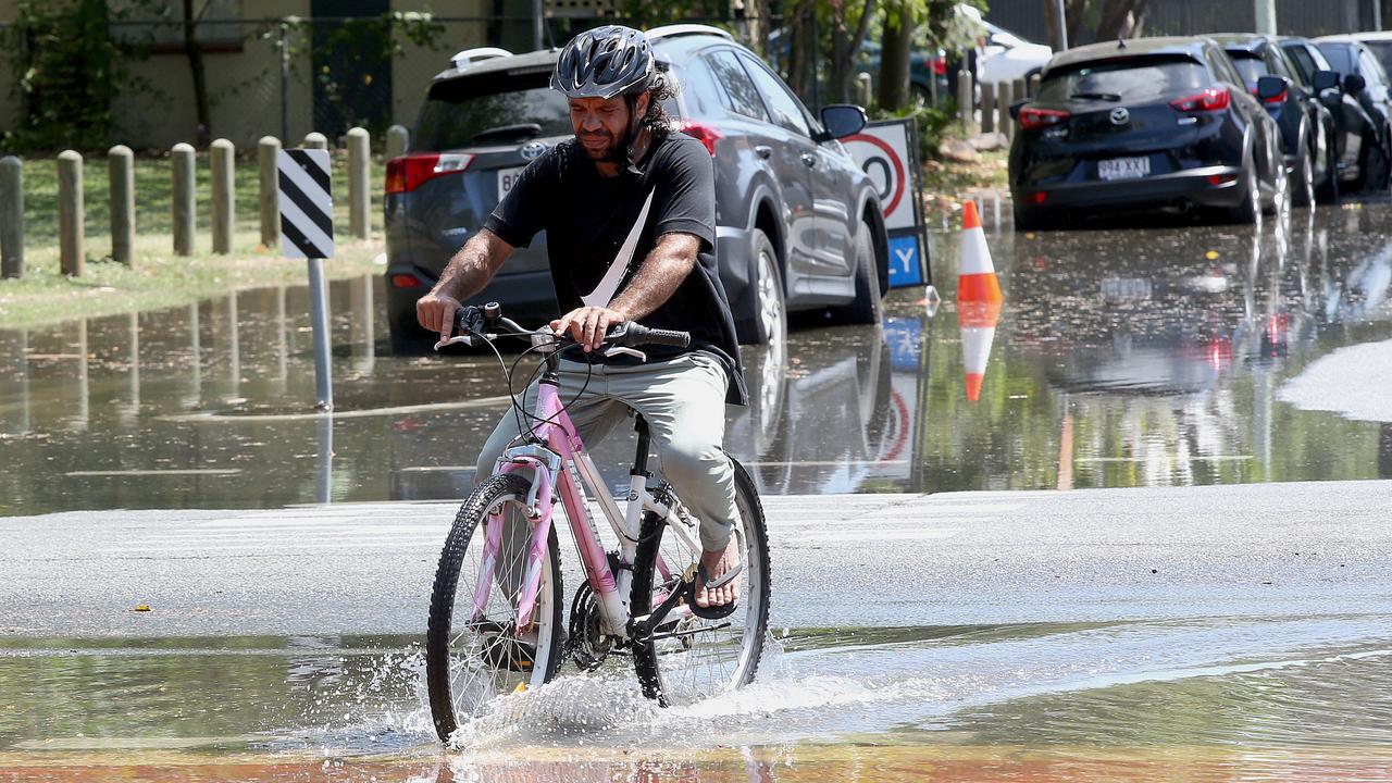 A man rides through low level flooding in the Brisbane suburb of Windsors. Picture: AAP