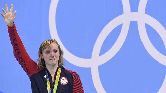 Katie Ledecky waves on the podium after winning the 800m freestyle.