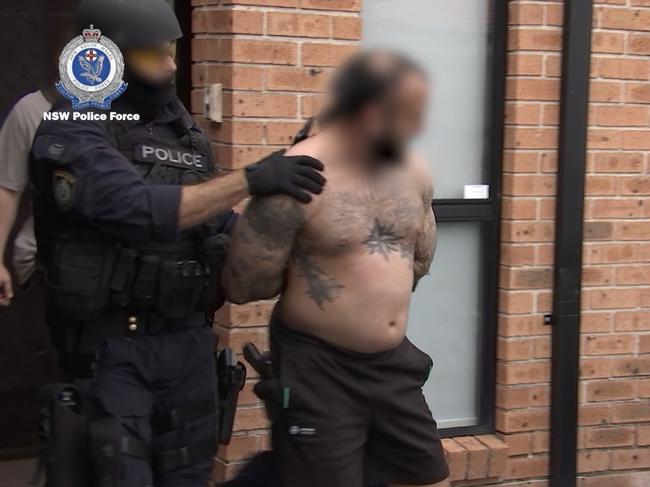 Alleged Rebels bikie Aleksander Mahone, 31, is arrested after allegations he choked and assaulted his partner. Picture: NSW Police Media