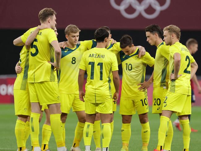 Australia's starting players gather on the pitch prior to their Tokyo 2020 Olympic Games men's group C first round football match between Australia and Spain at Sapporo Dome in Sapporo on July 25, 2021. (Photo by ASANO IKKO / AFP)