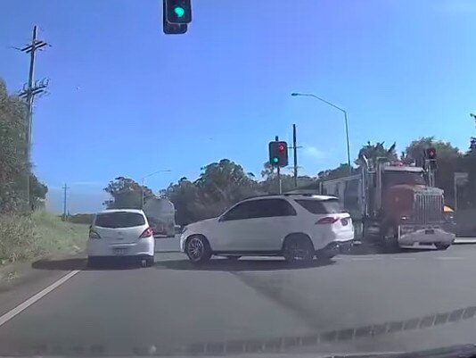 The car just missed being hit by a truck before it smashed into the white vehicle.