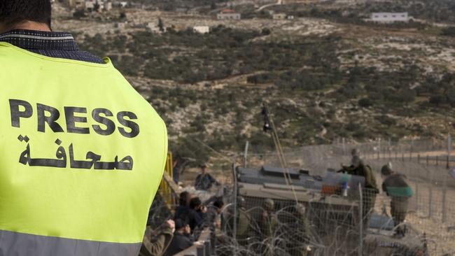 A journalist wears a marked vest near military in the West Bank. Picture: iStock