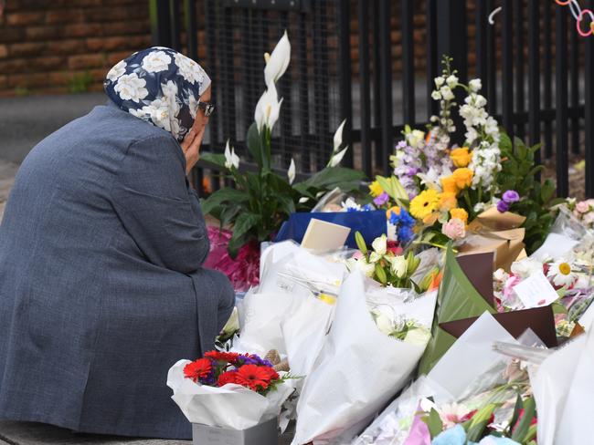 A woman reacts after placing flowers outside the school. Picture: Dean Lewins