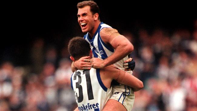 Grand Final Kangaroos vs Carlton : Kangaroos' Wayne Carey (R) leaps into the arms of Corey McKernan 25 Sept 1999 - sport AFL action victory celebrations