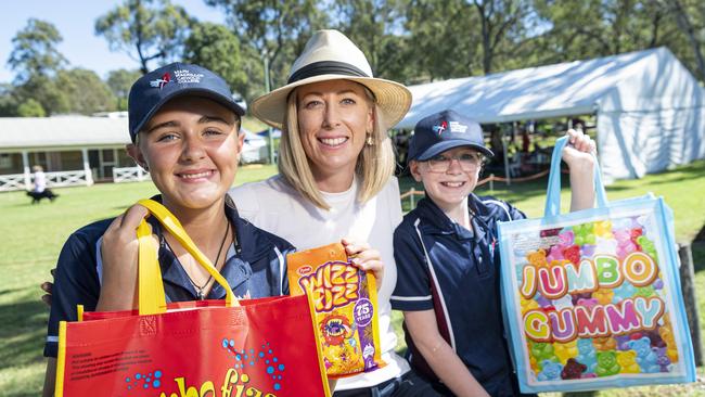 Mary MacKillop Catholic College students Claire Moylan (left) and Elliana Campbell take a break from marching band duties with Carmen Campbell at the Toowoomba Royal Show, Friday, April 19, 2024. Picture: Kevin Farmer