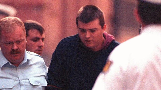 Paul Denyer being escorted by police in 1993 before he was handed three life sentences. Picture: Photo File