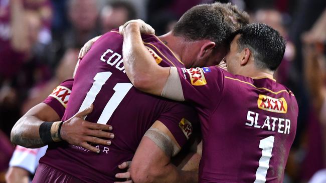 Maroons players celebrate a Valentine Holmes try against the Blues.