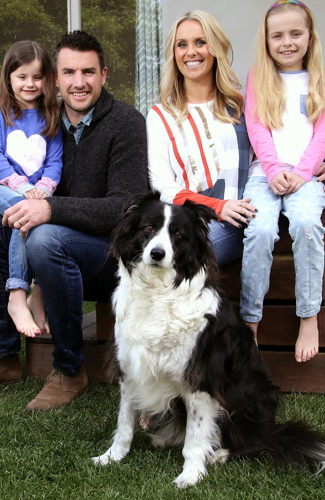 Former AFL footballer Darren Jolly with wife Dee — with daughters Scarlett (blonde hair) and Lily and dog Rosie — spent three months away from their family.