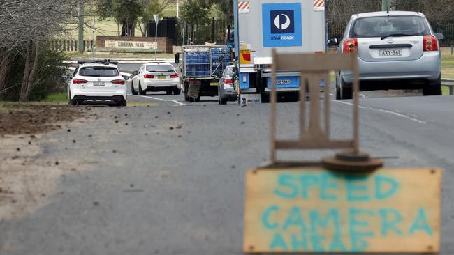 A hand-painted sign warns of a mobile speed camera.