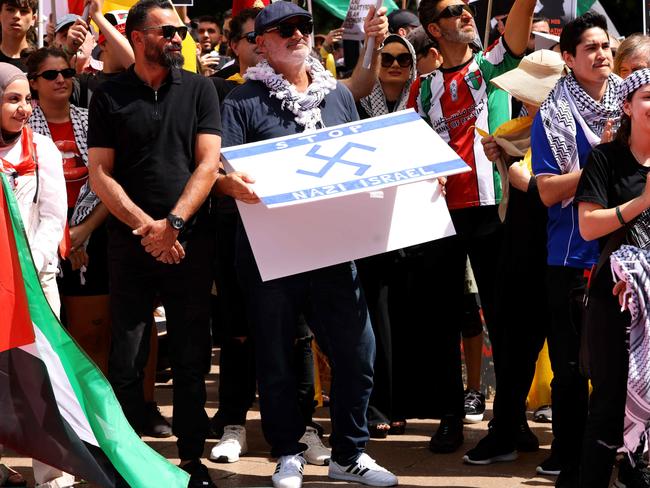 SYDNEY, AUSTRALIA - NewsWire Photos OCTOBER 6, 2024: A protester pictured holding  a flag that has a Nazi like symbol on it at the protest in Hyde Park. Protestors gather at Hyde Park in Sydney's CBD to demand an end to the ongoing war and Israel's current occupation of Gaza, and the escalating Israel-Lebanon conflict.Picture: NewsWire / Damian ShawAl Yazbek