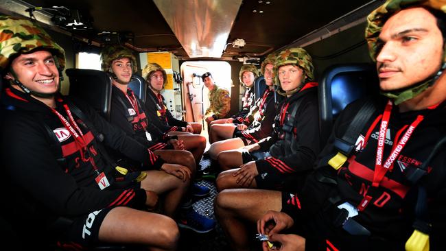 Essendon players ride in an Australian bushmast during their visit to the Simpson Barracks. Picture: Tony Gough