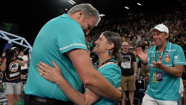 JackJumpers coach Scott Roth embraces Jo Harris, with husband Scott Harris at right.