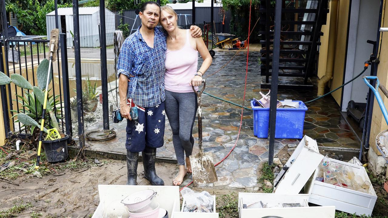 Caravonica residents Chris King and Krystal King comfort each other while cleaning up the flood water that inundated their Lake Placid Road home on December 17. Picture: Brendan Radke