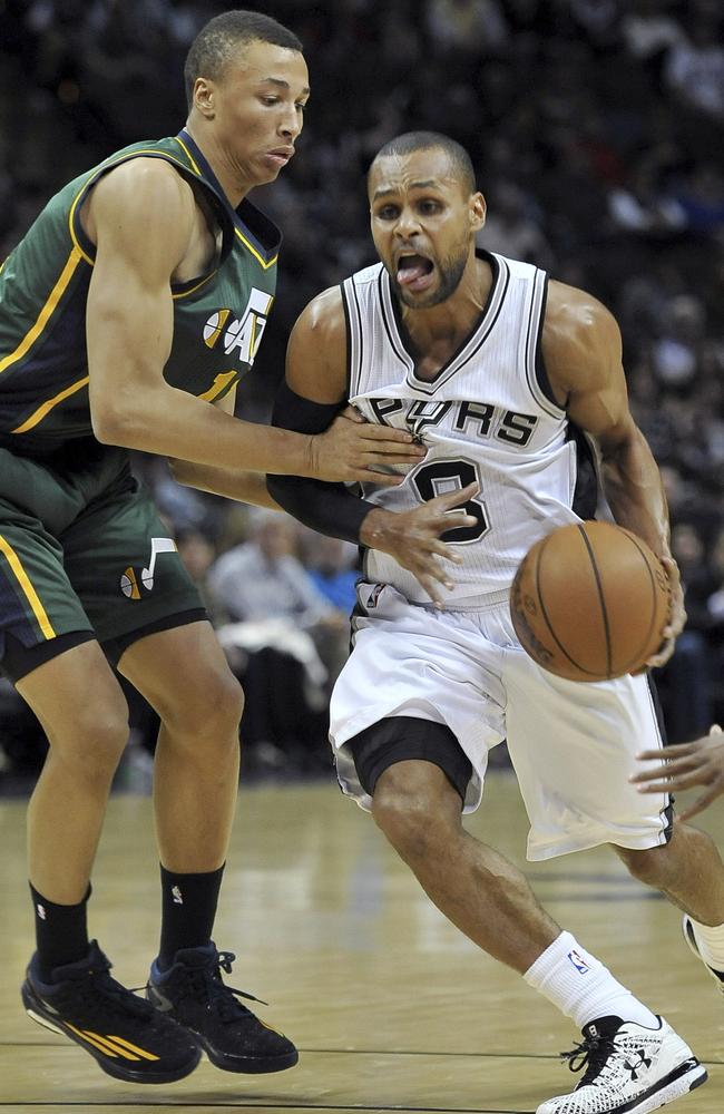 Patty Mills (R) drives around Utah Jazz guard Dante Exum.