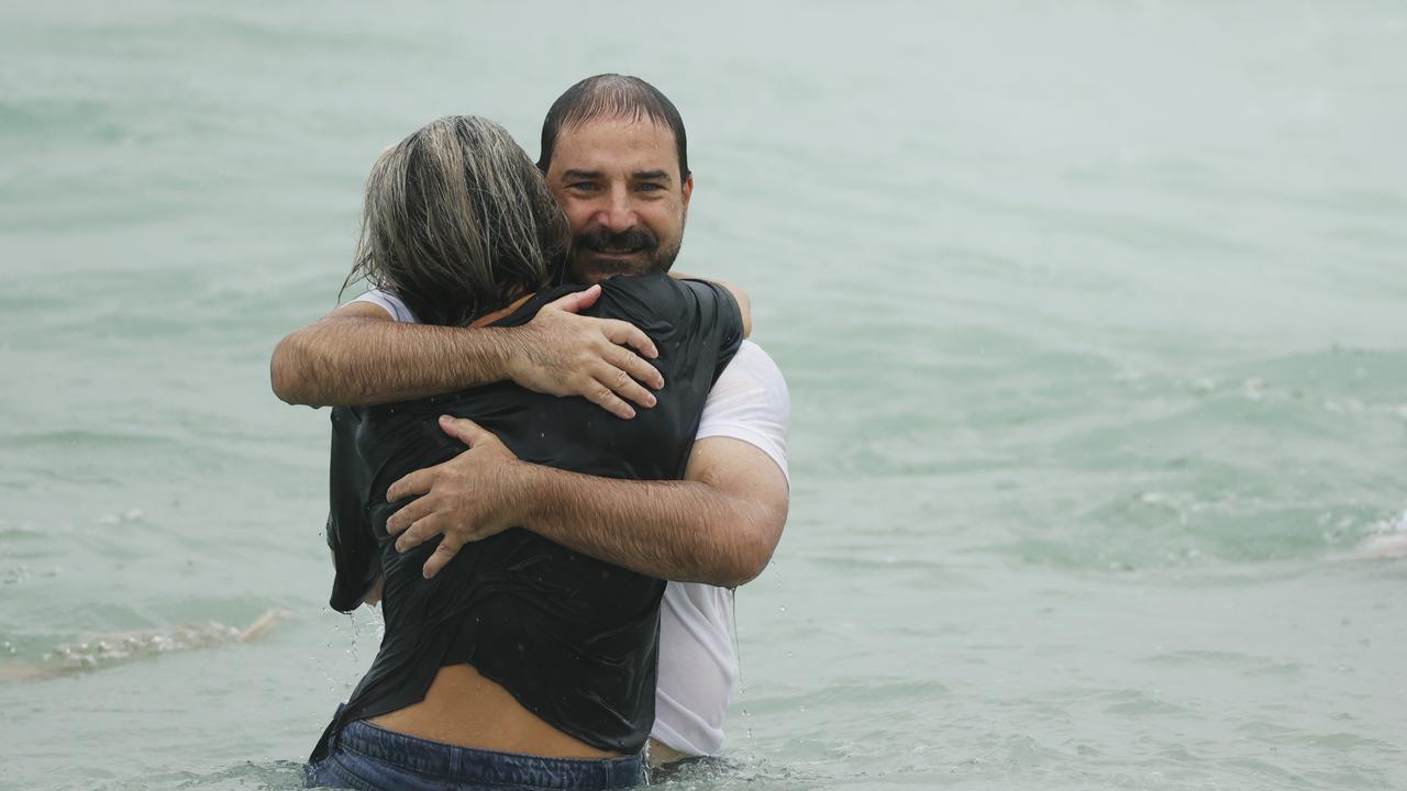 Father Michael Stewart receives a hug in the water at the tribute for his son, Balin Stewart, 16, at Buddina. Picture: Lachie Millard