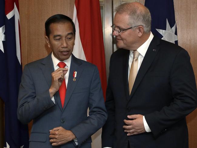 Indonesia's President Joko Widodo, left, and Australia's Prime Minister Scott Morrison chat during a signing ceremony at Parliament House in Canberra, Monday, Feb. 10, 2020. Widodo is on a two-day visit to Canberra, his fourth visit to Australia. (AP Photo/Rick Rycroft, Pool)