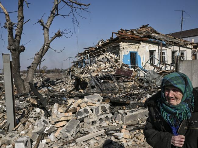 An elderly woman stands in front of a destroyed house after bombardments in the village of Krasylivka, east of Kyiv. Picture: AFP