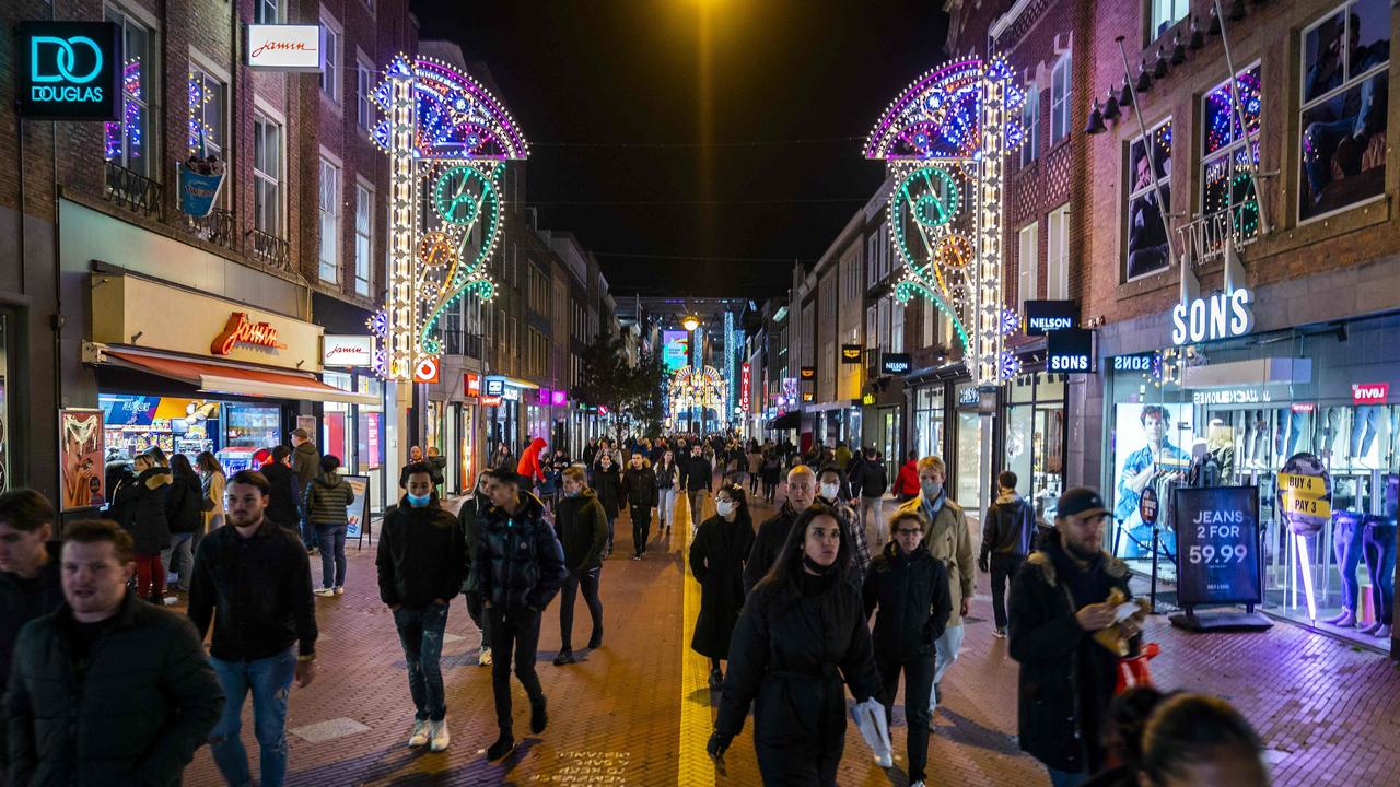 People walk in the streets, in Eindhoven after new Covid-19 restrictions as been announced by the Dutch Prime Minister, closing bars, restaurants and shops at 7 p.m. Photo by ROB ENGELAAR / ANP / AFP