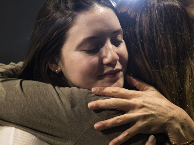 SHEFAYIM, ISRAEL - DECEMBER 10:  Released hostage, Agam Goldstein- Almog (L) hugs a community member during a Kfar Aza community event on the fourth night of Hanukkah on December 10, 2023 in Shefayim, Israel. Community members from Kfar Aza, a kibbutz in southern Israel, have been living in Shefayim, north of Tel Aviv, since the Oct. 7 attacks, in which dozens of Kfar Aza residents were killed, and others were kidnapped. Kfar Aza resident Chen Goldstein-Almog and three of her four children were released during last month's weeklong ceasefire. Her husband and one of her daughters were killed on Oct. 7.  (Photo by Amir Levy/Getty Images)