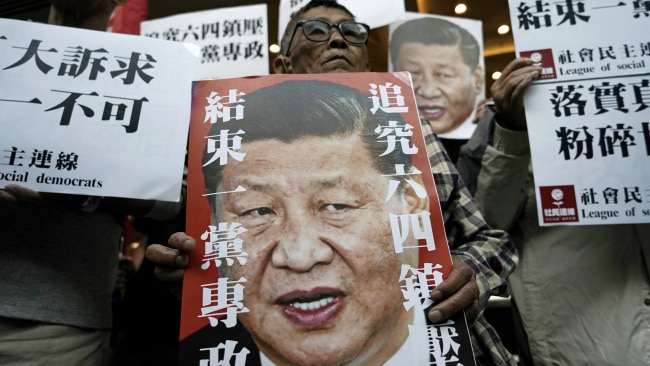 Pro-democracy activists hold up placards of Chinese President Xi Jinping with slogans including "End one party state" in Hong Kong. Picture: AP/Kin Cheung