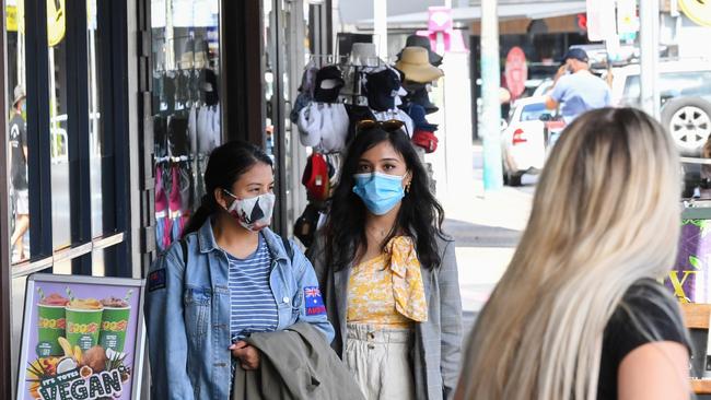 BYRON BAY, AUSTRALIA - MARCH 31: People wearing face masks walk along a street on March 31, 2021 in Byron Bay, Australia. The NSW Government has reintroduced restrictions for residents of Byron, Ballina, Tweed and Lismore shires after a new COVID-19 case was recorded in the area, linked to the current Brisbane coronavirus outbreak. Household gatherings will be limited to 30 people, venue caps will return to the four-square-meter rule and masks will be mandated in retail and public transport settings. The restrictions will remain in place until 11:59 pm on Monday 5 April. (Photo by James D. Morgan/Getty Images)