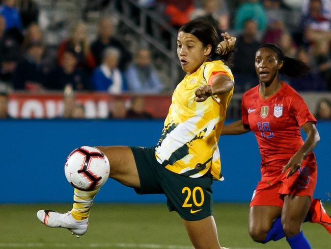 COMMERCE CITY, CO - APRIL 4: Sam Kerr #20 of Australia splits the defense and takes a shot as Alyssa Naeher #1, Crystal Dunn #19 and Becky Sauerbrunn #4 of the United States defend during the first half at Dick's Sporting Goods Park on April 4, 2019 in Commerce City, Colorado.   Justin Edmonds/Getty Images/AFP == FOR NEWSPAPERS, INTERNET, TELCOS & TELEVISION USE ONLY ==