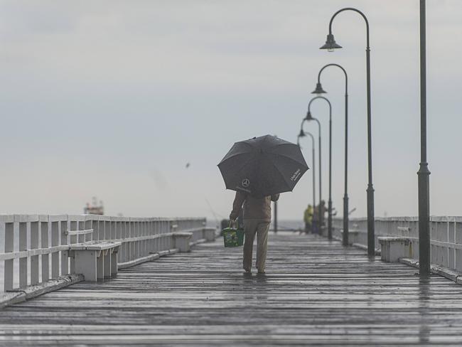 Storm. The storm that flooded Geelong has hit Melbourne. A man holding an umbrella makes his way trough the rain, up the Kerferd Road Pier. Picture: Eugene Hyland