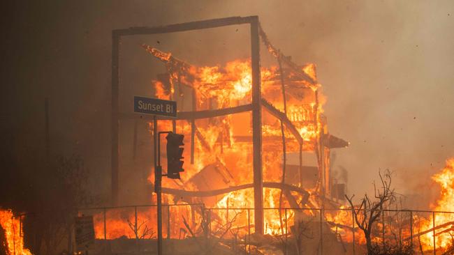 Flames from the Palisades Fire burn a building on Sunset Boulevard amid a powerful windstorm in the Pacific Palisades. Picture: Apu Gomes