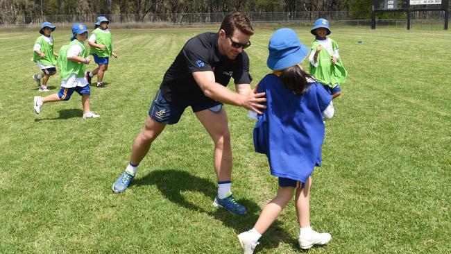 Wallaby Bernard Foley helps students from St Andrews with their skills.