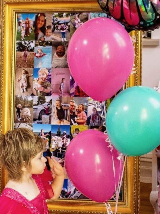 Valentina standing by her frame of memories at her third birthday party. Picture: Supplied