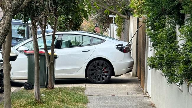 A Tesla blocking a footpath while being charged. Pic. Snap Send Solve