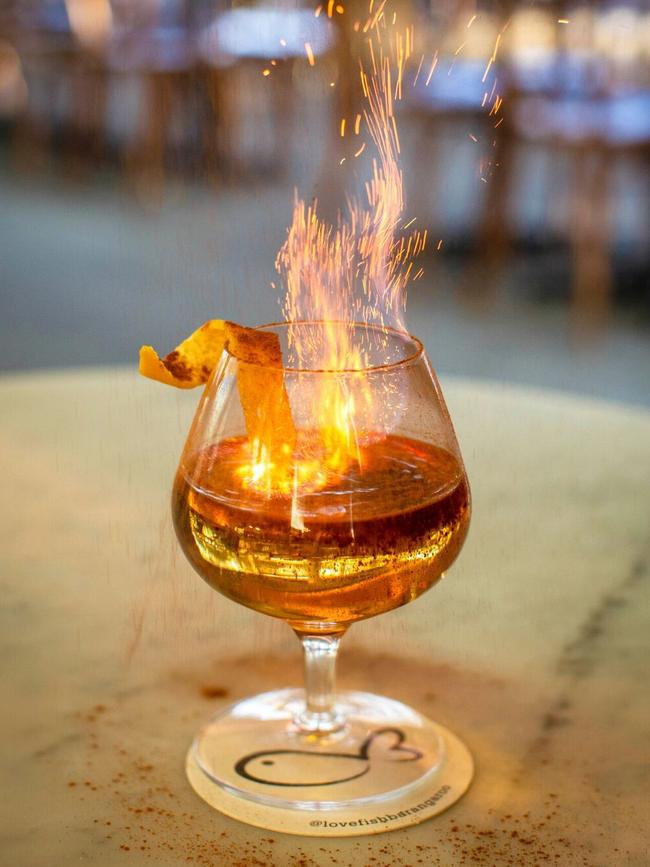 Restaurants and bars at Barangaroo have created unique cocktails for Vivid including the flaming orange winter spice cocktail at Love Fish.