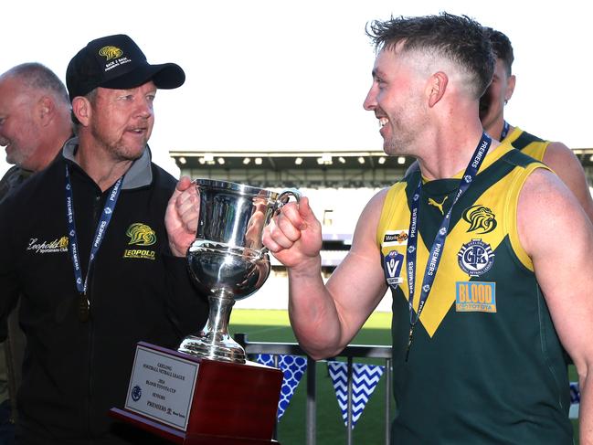 GFNL  Grand Finals. Seniors. South Barwon v Leopold.  Leopold Captain Matt Caldow celebrates with the Coach Garry Hocking and the priemership trophy. Picture: Mike Dugdale