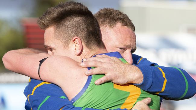 Golden Grove coach Eric Kells hugs player Oliver Graham following the Kookaburras’ division three grand final victory over Flinders Park. Kells dedicated the victory to his late father, John Kells, who died three weeks ago. Picture: Emma Brasier