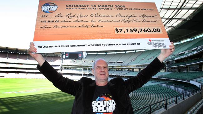 Michael Gudinski with the initial cheque from Sound Relief, before DVD sales. Picture: News Corp