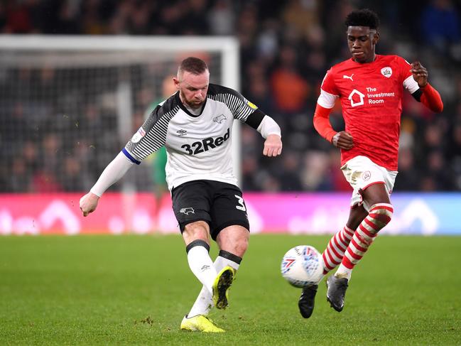 DERBY, ENGLAND - JANUARY 02: Wayne Rooney of Derby County passes the ball while under pressure from Elliot Simoes of Barnsley during the Sky Bet Championship match between Derby County and Barnsley at Pride Park Stadium on January 02, 2020 in Derby, England. (Photo by Laurence Griffiths/Getty Images)