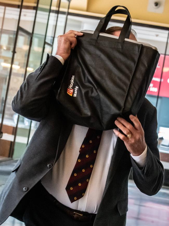Robert Eaglesham hides his face from the Manly Daily outside the Downing Centre. Picture: Monique Harmer.