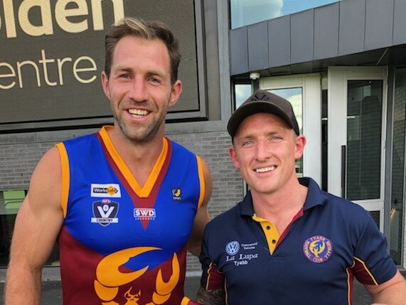 Travis Cloke tries on a Tyabb jumper alongside Yabbies coach Aaron Pacey.