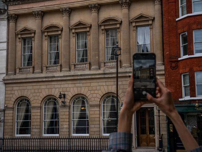 A woman photographs the Carlton Club, a private members club founded in 1832, where Conservative MP Chris Pincher is alleged to have groped two men.